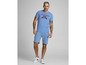 Ein Mann in einem blauen T-Shirt mit 'Athletic Div.' Print und passenden blauen Shorts.