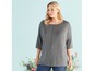 Eine Frau trägt ein graues Oberteil mit Dreiviertelärmeln.
