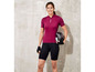 Eine Frau trägt ein rosafarbenes Radtrikot und schwarze Radshorts.