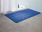 Eine blaue Badezimmermatte mit Chevron-Muster.
