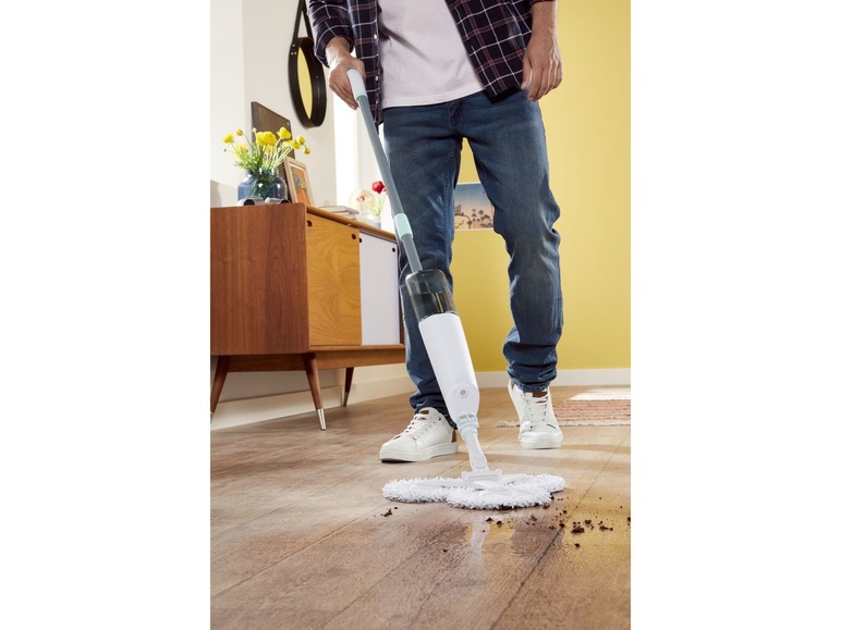 Ein Mann reinigt einen Holzboden mit einem Vileda-Sprühmopp.