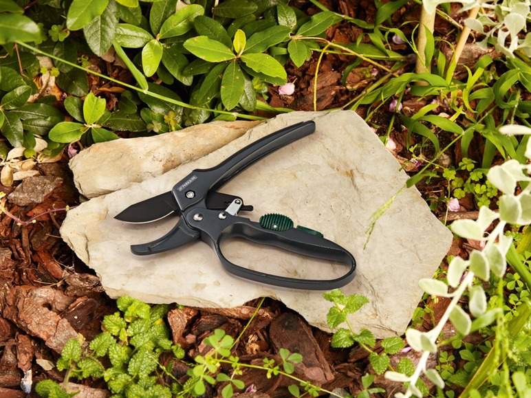Gartenschere auf einem Stein im Garten.