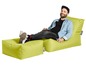 Ein Mann entspannt sich auf einem limegrünen Sitzsack der Marke Sitting Point.