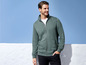 Ein Mann trägt einen grünen Reißverschluss-Pullover von Sailing.