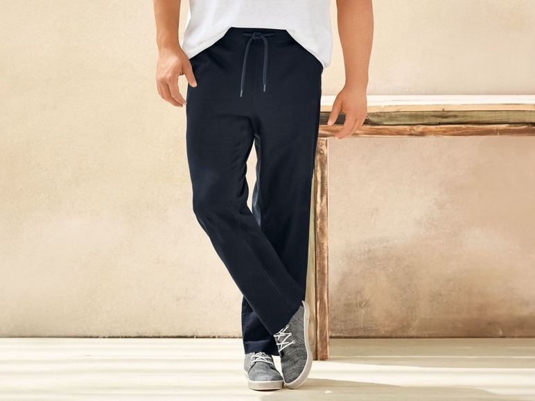 Mann trägt blaue Jogginghose und weiße Sneakers.