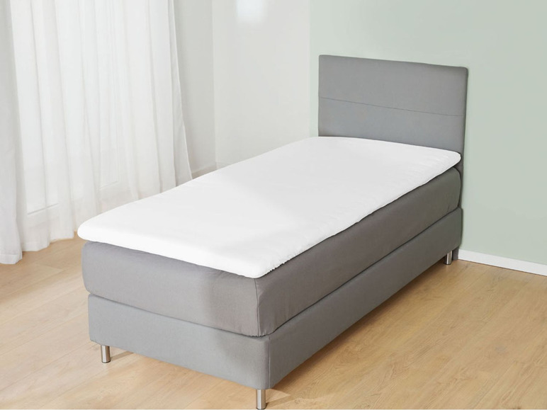 Ein graues Bettgestell mit einer weißen Matratze.