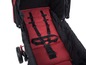 Ein roter Kinderwagen mit schwarzem Verdeck und Sicherheitsgurt.