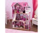 Ein mehrstöckiges Puppenhaus in Rosa mit Bad, Schlafzimmer und Küche.