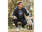Mann mit Kapuzenpullover und Jeans posiert mit einem Border Collie.