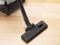 Ein schwarzer Staubsaugerkopf auf einem Holzboden.