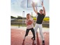 Zwei Personen spielen Basketball auf einem Außenplatz.