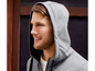 Mann in einem grauen Hoodie mit schwarzem Reißverschluss.