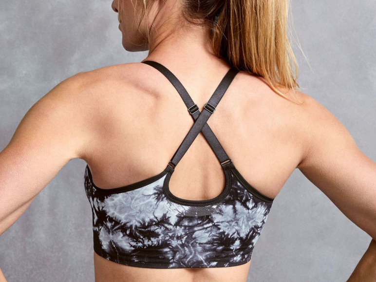 Frau mit einem schwarzen Sport-BH mit Tie-Dye-Muster.