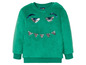 Grüner Wollpullover mit glitzernden Augen.