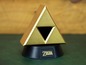 Eine goldene Zelda Triforce-Figur auf einem schwarzen Sockel