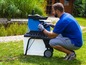 Ein Mann verwendet einen blauen elektrischen Häcksler im Garten.
