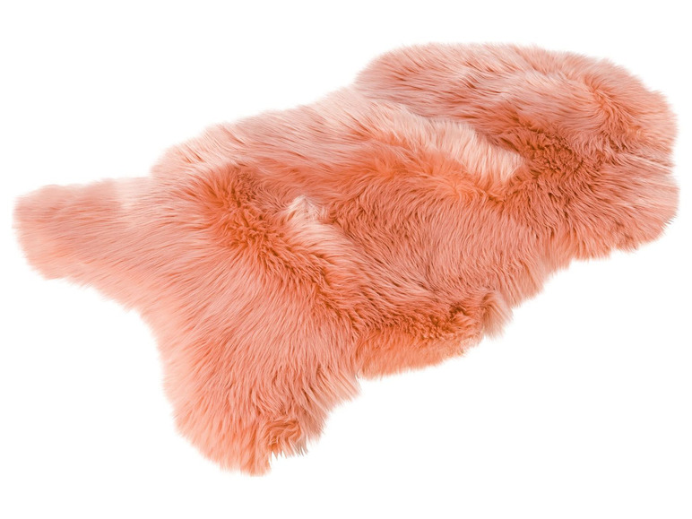 Ein rosa Lammfellteppich für den Boden.