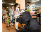Ein Doppelkinderwagen mit zwei Babysitzen in einem Supermarkt.