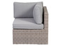 Eine graue Eckcouch mit Wicker-Gestell und Kissen.