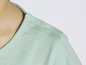 Ein hellgrünes T-Shirt mit Knöpfen auf der Schulter.