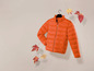 Eine orangefarbene Winterjacke mit Herbstblättern.