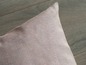 Ein rosa Kissen aus Stoff mit grob gewebter Textur.