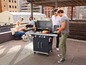 Eine Gruppe von Leuten genießt ein Barbecue auf einer Dachterrasse.