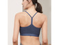Eine Frau trägt einen blauen Sport-BH mit Racerback.