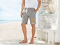 Mann in grauen Shorts mit Aufdruck am Strand.