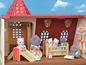 Sylvanian Families Spielzeug mit Puppen, Möbeln und einer Rutsche in einem Haus.