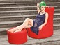 Eine Frau sitzt auf einem roten Beanbag-Sessel mit passendem Hocker.
