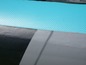 Detail eines aufblasbaren Paddleboards mit einem türkisfarbenen Deck und schwarzen und grauen Seiten.