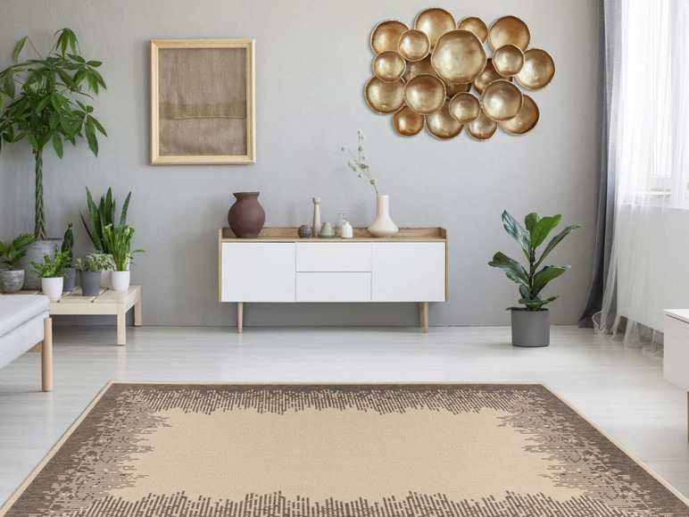 Beigefarbener Teppich mit dunkelgrauem Rand in einem modernen Wohnzimmer mit weißem Sideboard und goldener Wanddeko.