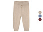 Beige gestrickte Babyhose mit Knöpfen.