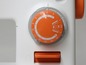 Nahaufnahme einer Nähmaschine mit einem orangenen Drehknopf zur Stichwahl.