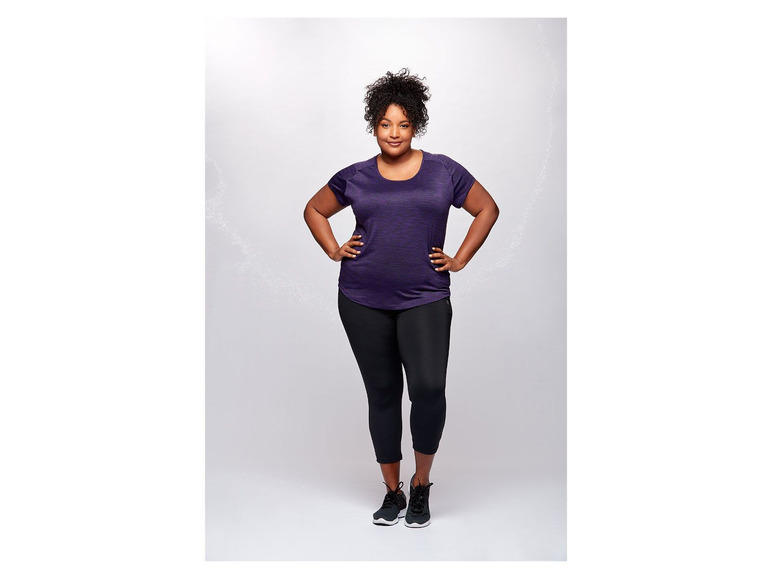 Eine Frau trägt schwarze Leggings und ein lila T-Shirt