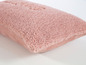 Ein rosa Kissen aus Kunstfell.