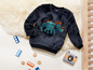 Ein dunkelblauer Pullover für Kinder mit einem Dinosaurier-Motiv.