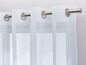 Weiße Vorhänge mit Ösen an einer Stange