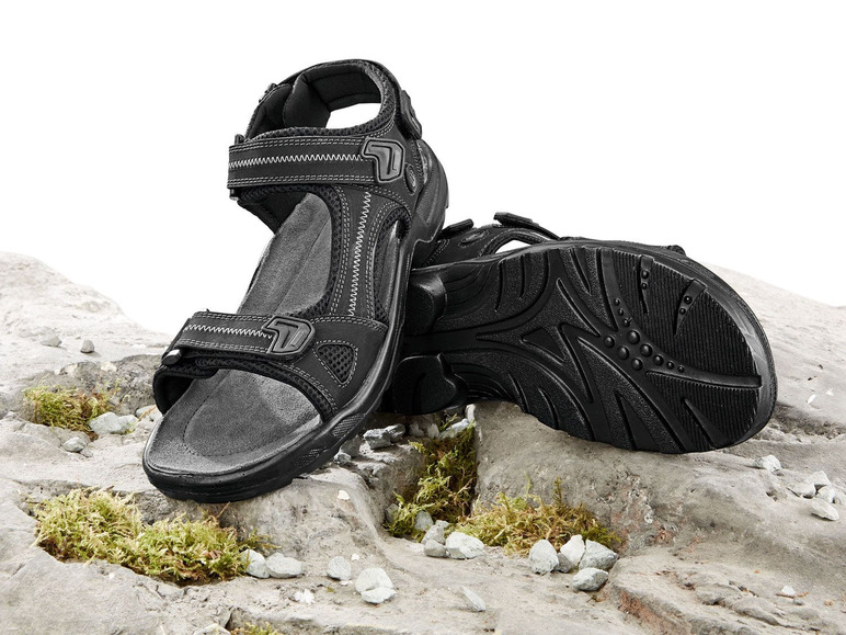 Schwarze Sandalen mit Schnallen auf Felsen