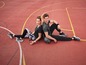 Ein Mann und eine Frau in Sportkleidung posieren auf einem Basketballfeld mit einem Ball.
