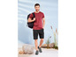 Mann mit T-Shirt, Shorts und Rucksack auf dem Strand.