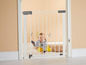 Ein Baby hinter einem weißen Sicherheitstor von Summer Infant.