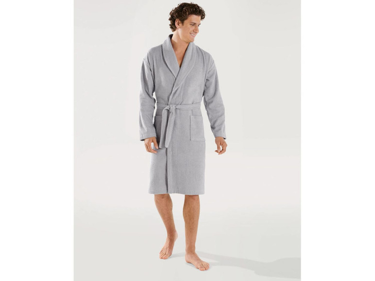 Ein Mann trägt einen grauen Bademantel.
