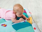 Ein Baby liegt auf einer Spielmatte von Taf Toys.
