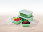 Ein Set grüner Aufbewahrungsbehälter mit Deckeln, gefüllt mit Obst.