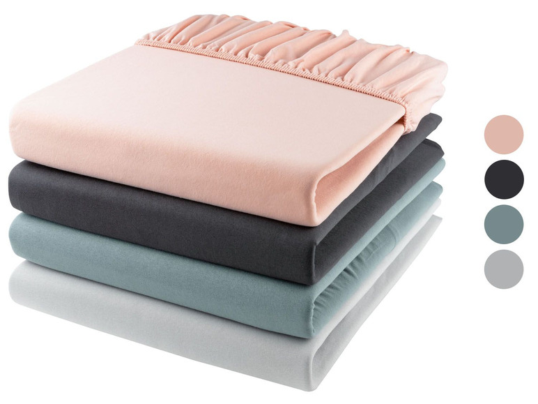 Ein Stapel Bettwäsche in Rosa, Grau, Hellblau und Weiß.