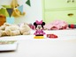 Eine rosafarbene LEGO Minnie Mouse Figur mit zusätzlichen Teilen auf einem weißen Boden.