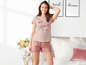 Model in Pyjama mit rosafarbenem T-Shirt mit dem Aufdruck 'set yourself free' und gestreiften Shorts.