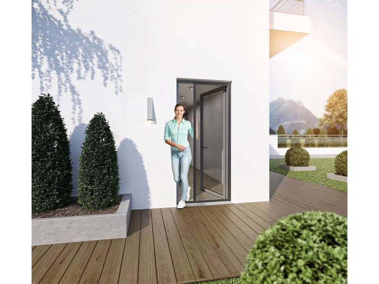 Eine Frau steht in einer Tür, die zu einer Terrasse mit Holzboden führt.